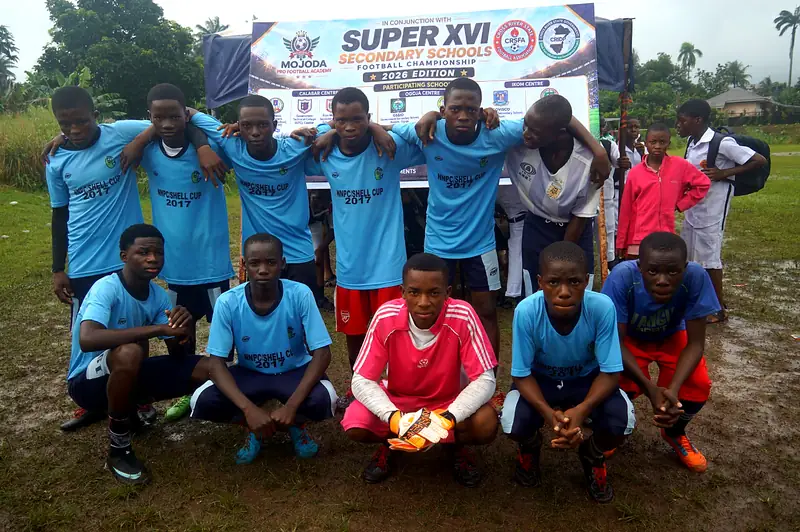A team in sky blue kit posing in front of the tournament banner