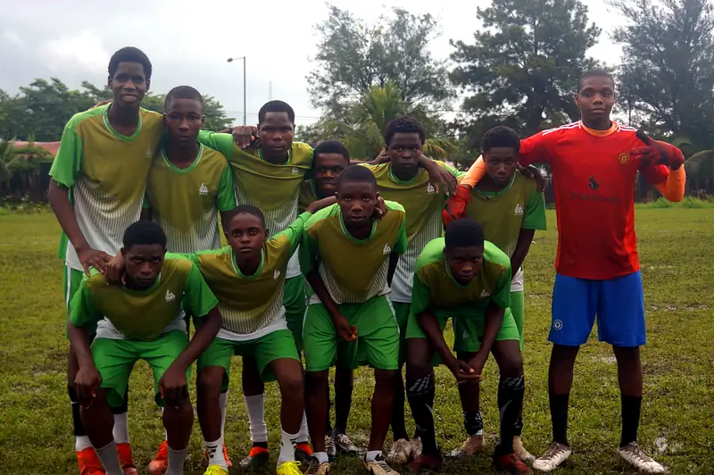 A team in green kit with a goalkeeper in red posing before the match