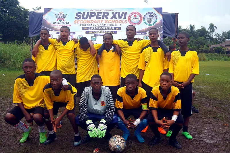 A team in yellow kit posing in front of the Super XVI championship banner