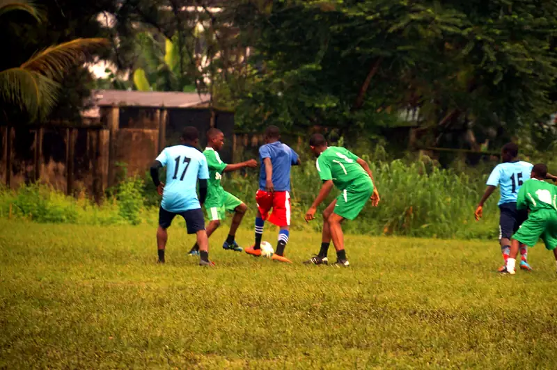 Three players competing for the ball in the middle of the pitch